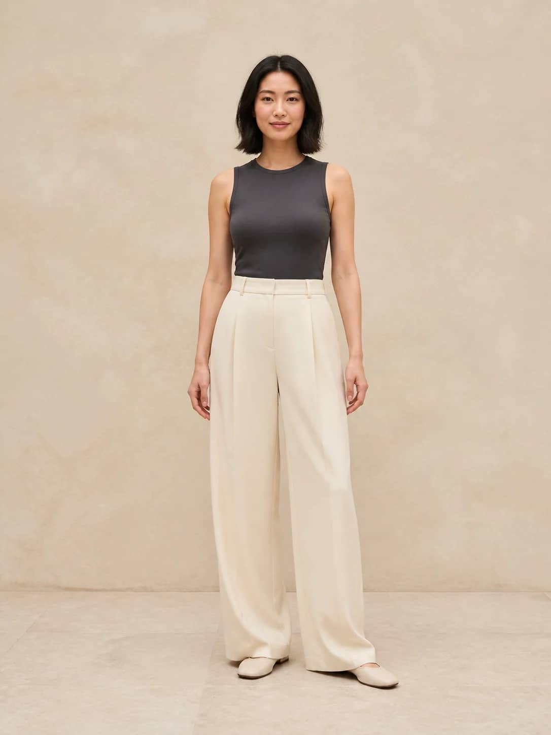 East Asian woman in a charcoal top and cream trousers used as a virtual try-on person photo