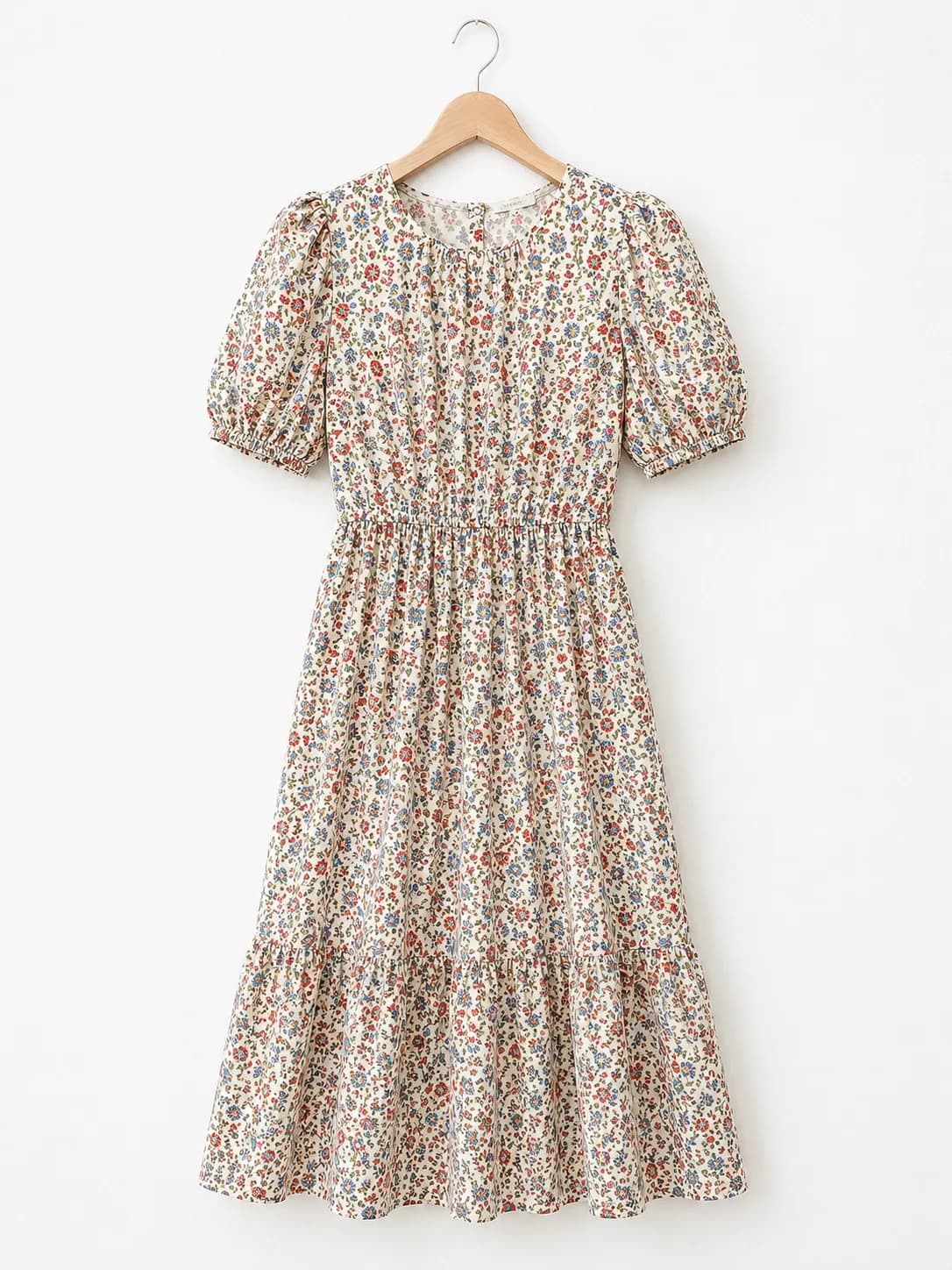 Floral midi dress with a dense repeating print photographed on a hanger