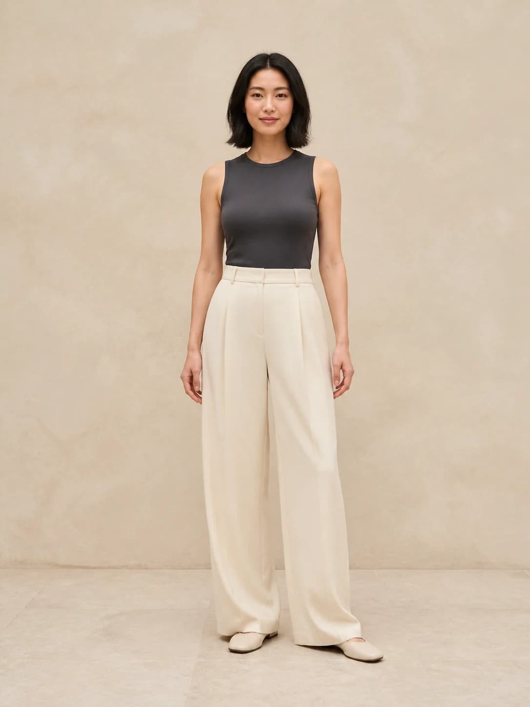 East Asian woman in a charcoal top and cream trousers used as a virtual try-on person photo